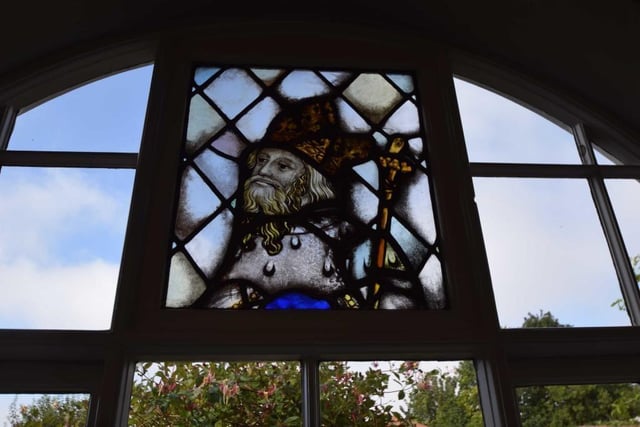 The arched lounge window includes this stained glass element.