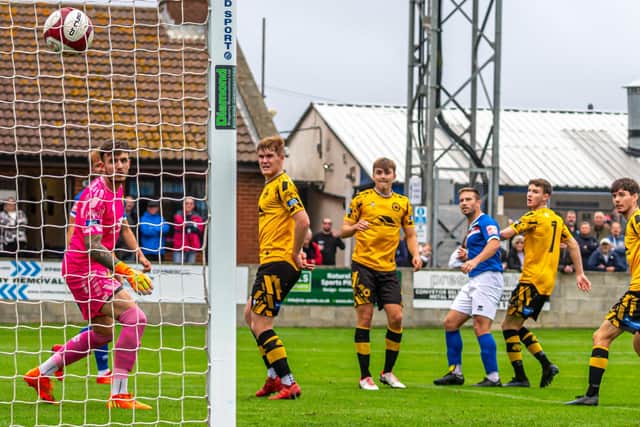 Whitby Town's Adam Gell (third from right) curls ball into goal to put the home side 2-0 ahead against Prescot Cables in the FA Cup clash. PHOTOS BY BRIAN MURFIELD