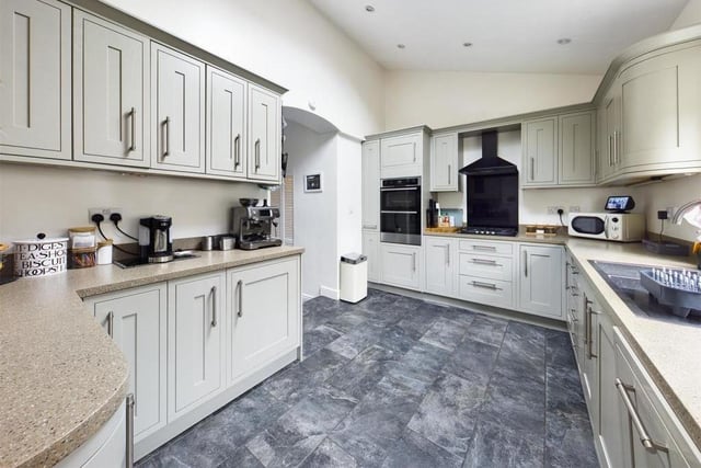 The fitted kitchen with spotlights has a door leading out to the garden.