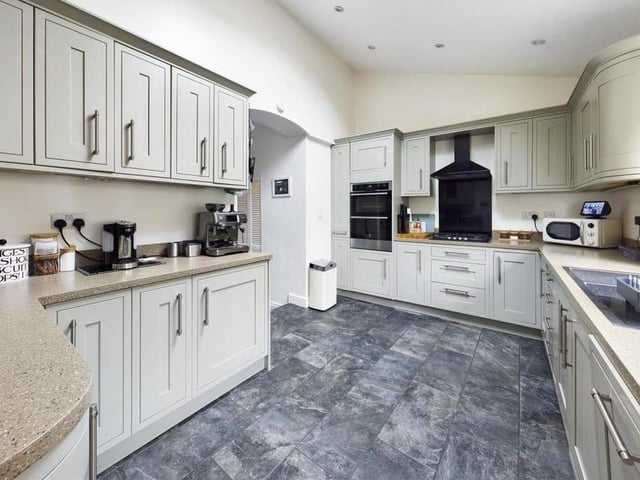 The fitted kitchen with spotlights has a door leading out to the garden.