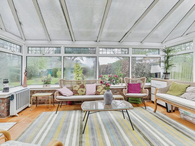 The conservatory has doors out to the surrounding garden.