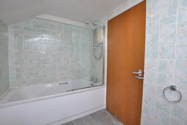 A house bathroom with bath and overhead shower.