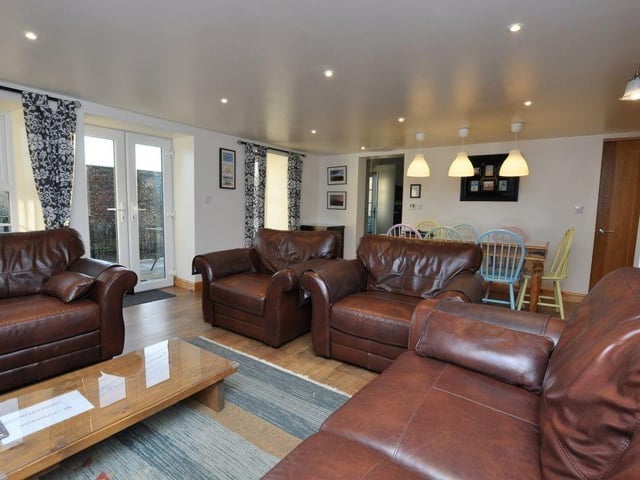 A modern open plan lounge and diner has French Doors out to a terrace, and also leads through to the kitchen, that has fitted cabinets and integrated appliances.