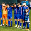 The Whitby Town players observe a minute's silence in tribute to former manager Tony Lee. PHOTO BY BRIAN MURFIELD