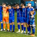 The Whitby Town players observe a minute's silence in tribute to former manager Tony Lee. PHOTO BY BRIAN MURFIELD