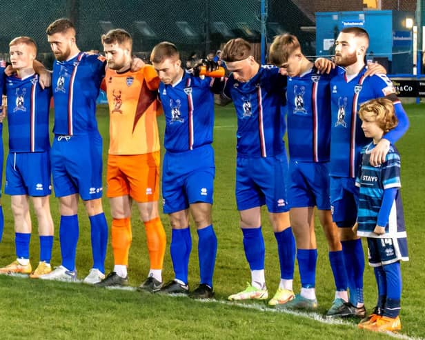 The Whitby Town players observe a minute's silence in tribute to former manager Tony Lee. PHOTO BY BRIAN MURFIELD