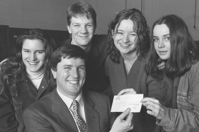 Terence Higgins Trust speaker Max Potter, front, received a £300 cheque from four members of the Sixth Form College Charities Committee Group in January, 1993. From left, Cheryl Binnis, Martin Bradnam, Eliza Carthy and Liz Williams. 