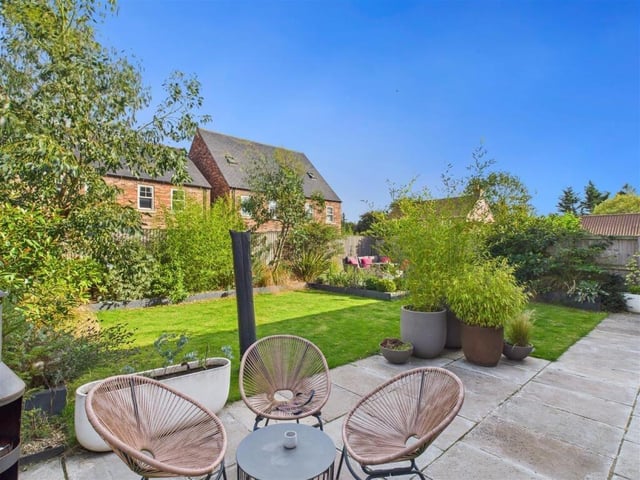 Another view of the lawned garden with patio and seating areas.