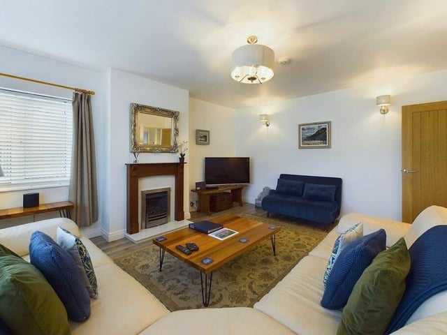 The lounge has a cosy fireplace, and a large picture window through which natural light pours in.