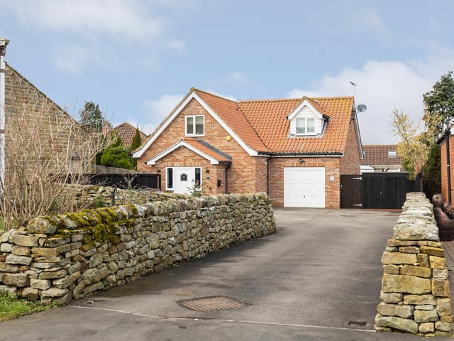 The driveway within stone walls leads up to the four bedroom property.