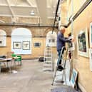 Curator Rob Moore hangs some of the pictures which form the Inprint exhibition at the Old Parcels Office