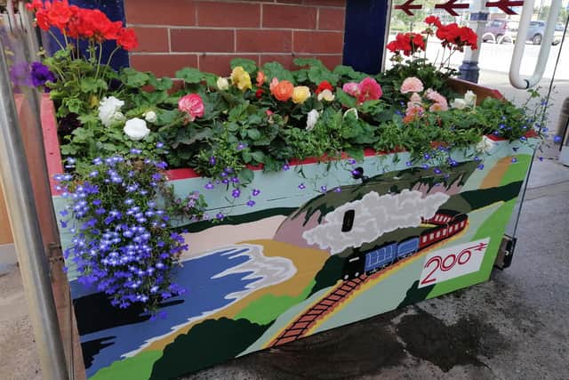 The new planter with beautiful blooms growing.