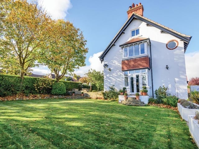 The lawned garden area with planters and hedging to either side.