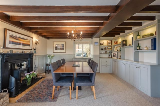 The beamed dining room has a feature fireplace and built-in cabinetry.