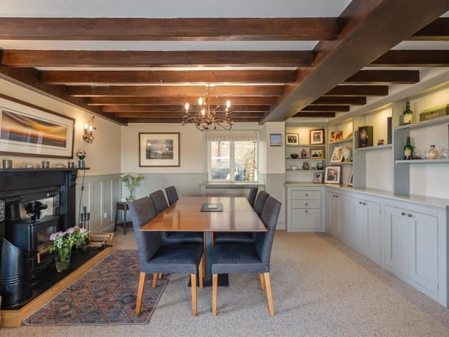 The beamed dining room has a feature fireplace and built-in cabinetry.