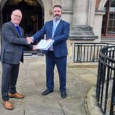 Chris Hall, from SHOUT, hands the petition to Daniel Harry, North Yorkshire Council's head of democratic services.