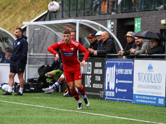 Defender Alex Brown takes a Boro throw while fans look on.