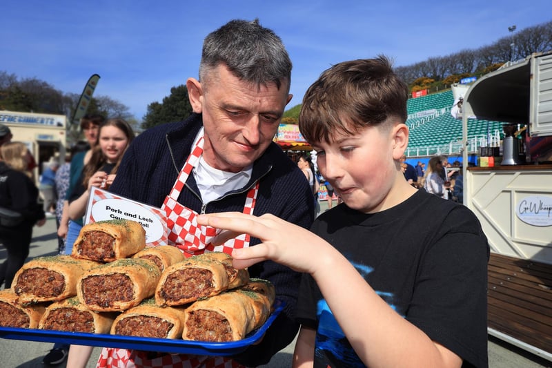 Phil offers an scrumptious sausage roll to Alfie.