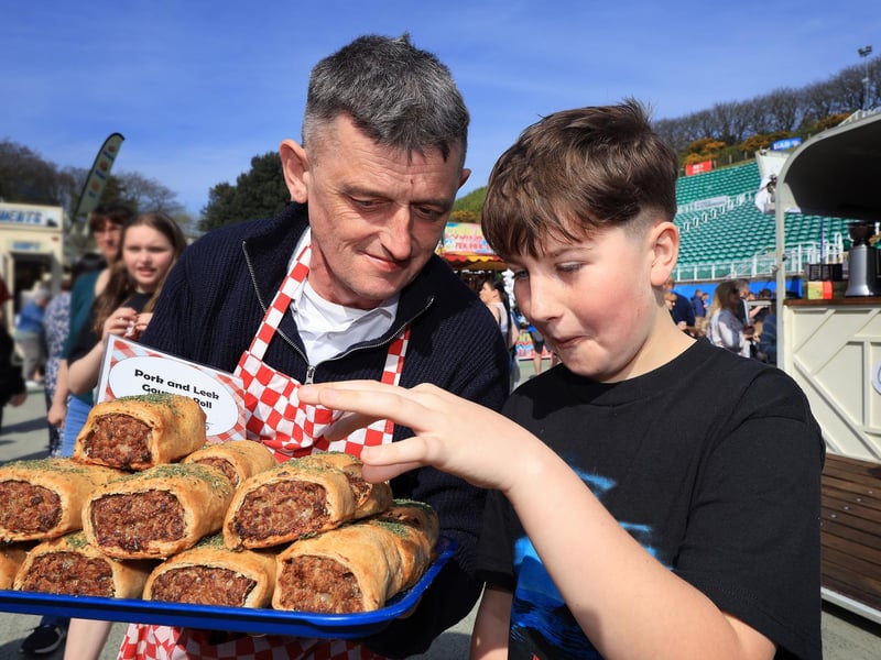 Phil offers an scrumptious sausage roll to Alfie.