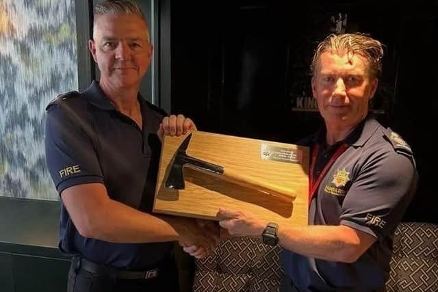 Firefighter Paul Robson is presented with a commemorative fire axe. Photo courtesy of Humberside Fire & Rescue Service