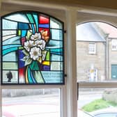 Rev Josephine Secker admires the new stained glass window at Lythe Village Hall.