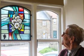 Rev Josephine Secker admires the new stained glass window at Lythe Village Hall.