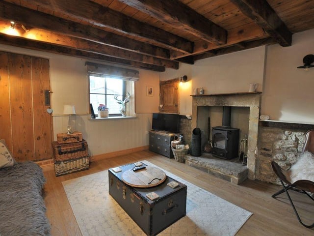 The beamed lounge has original woodwork and a stone fireplace with log-burning stove, that has a salt store by its side.