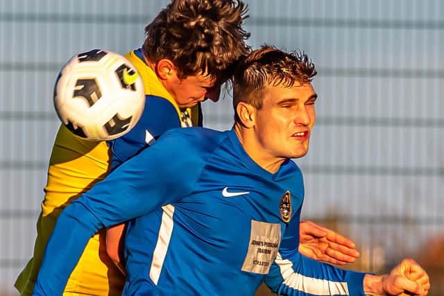 Jake Faichney challenges for a header for the Fishermen