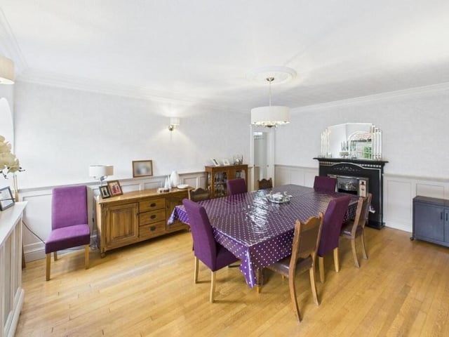 Dining space with parquet flooring, arched windows, and a feature cast iron fireplace.