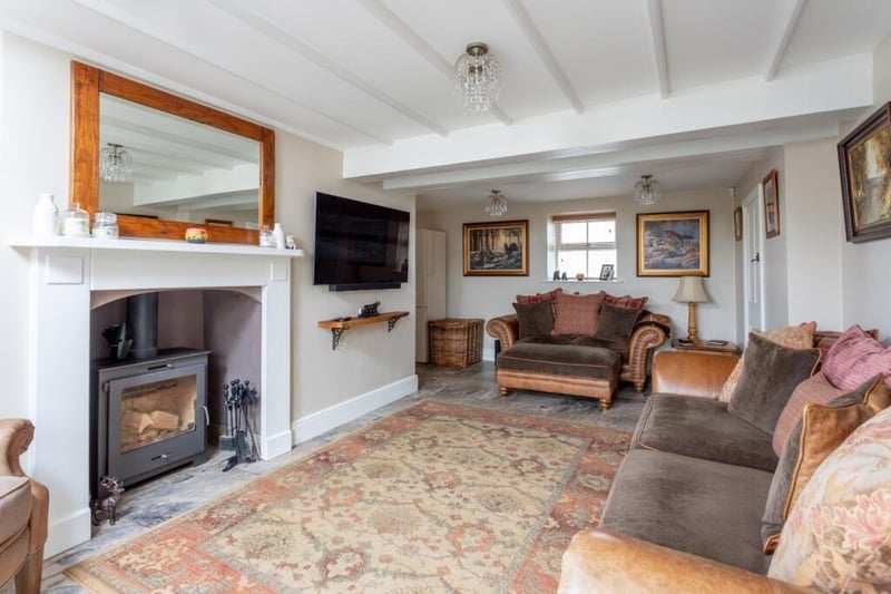 A large fireplace and stove is central to this reception room.