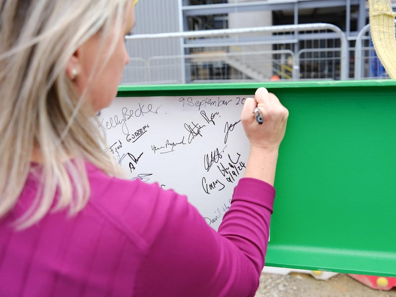Kelly Becker, President at Schneider Electric, UK & Ireland, Belgium & Netherlands signing the girder