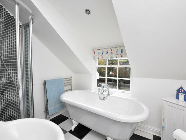 A roll-top bath is a feature of the main bathroom on the upper floor.