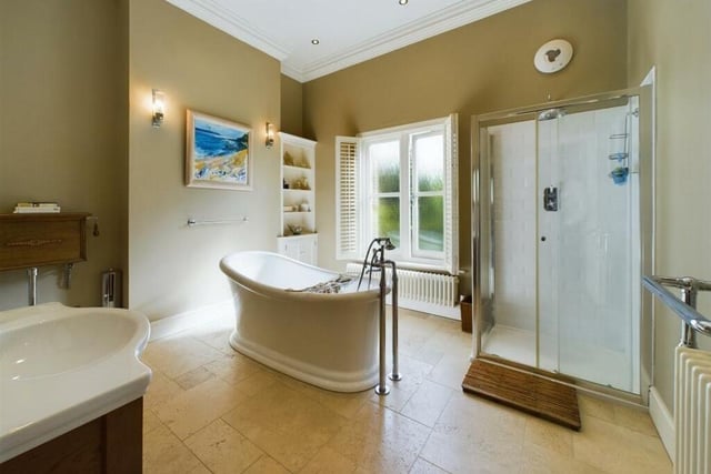 The family bathroom has a central free-standing bathtub, with a separate walk-in shower.