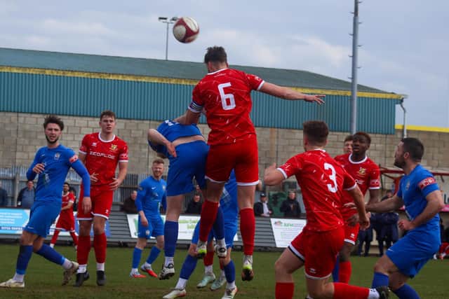 Brid skipper Tom Allan rises highest to win a header against Blyth Town. Photo by ECmedia