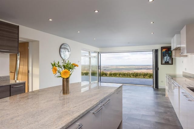 Stylish indoor to outdoor living: bi fold doors open to a terrace from the kitchen and diner.