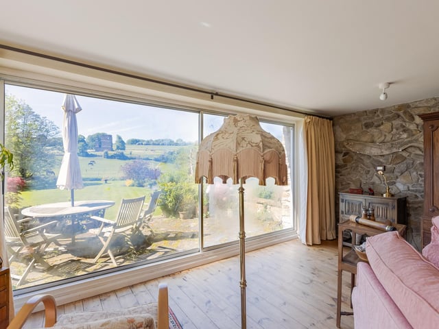 A large picture window shows the castle ruin and countryside to best advantage.