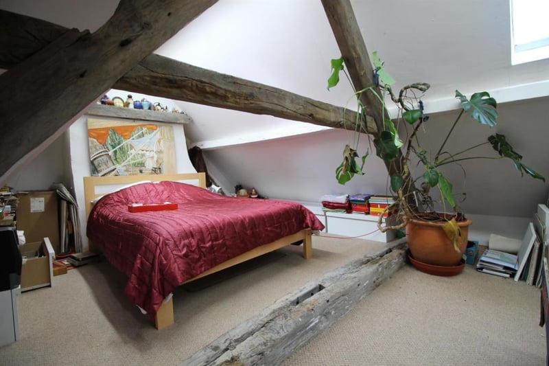 An upper floor bedroom with exposed timbers.