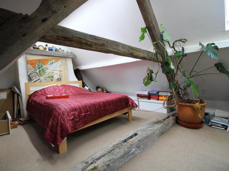 An upper floor bedroom with exposed timbers.