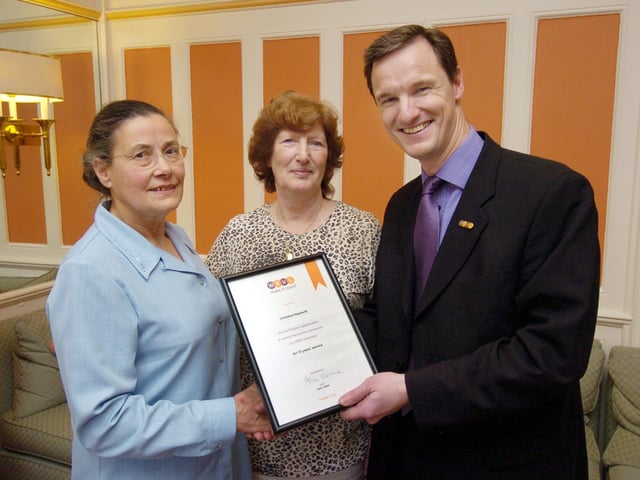 Christine Hepworth (L) receives a surprise presentation for long service to the WRVS, from Mark Lever, chief exec of WRVS. Also pictured is Lily Carling, of Scarboro WRVS.