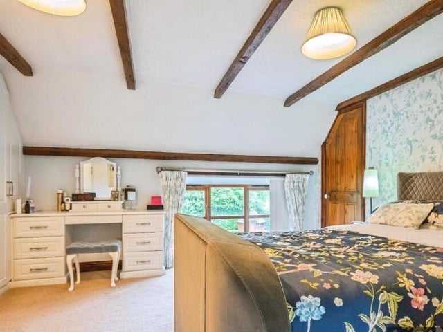 One of the property's four bedrooms with ceiling beams.