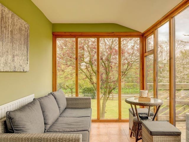 The conservatory opens to a raised area of decking, with rural views.