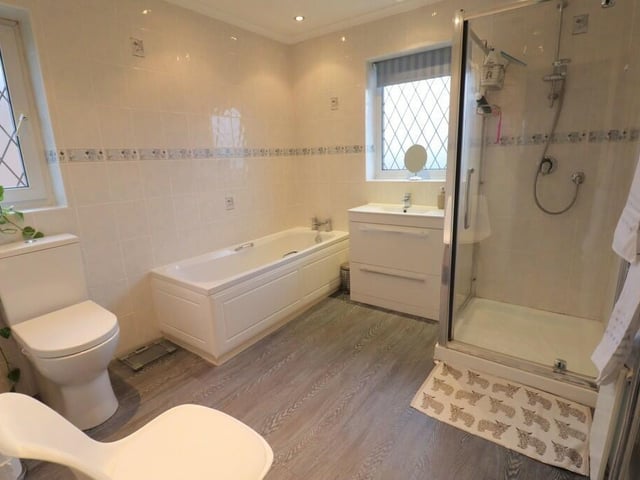 The family bathroom has a suite that includes both bath and separate shower, with wash basin and vanity unit.