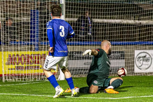 Sam Collins nutmegs Hednesford keeper Tony Breeden to make it 2-0 to Whitby. Photo by Brian Murfield