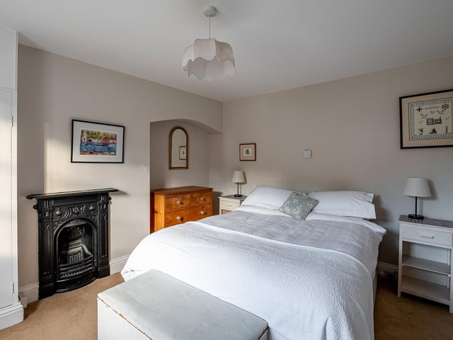 A period fireplace and an alcove add to the character of this bedroom