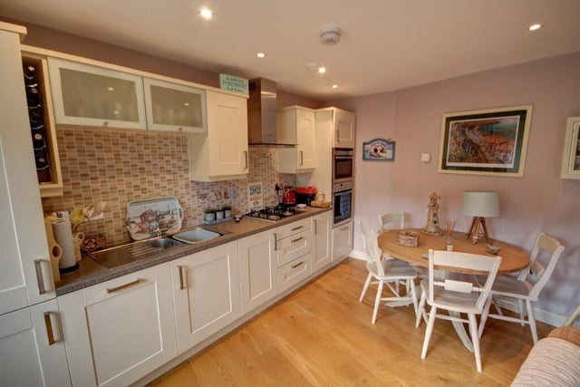 A kitchen with fitted units and integrated appliances.