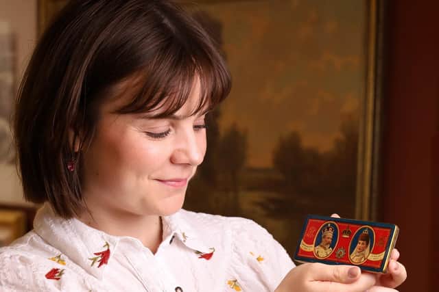 Holly Hammond with the 125-year-old silver chocolate tin made for the coronation of King Edward VII. David Duggleby Auctioneers© SWNS