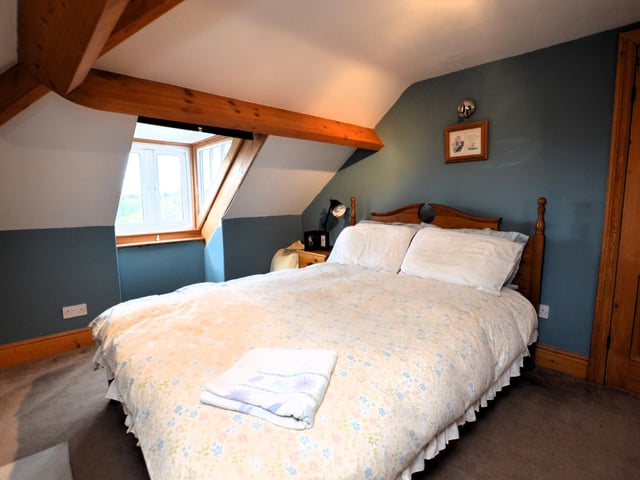 A third floor double bedroom, with exposed beams.