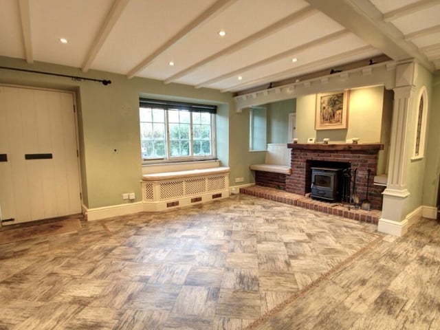 The kitchen with dining room has an Inglenook style fireplace with a brick surround and a multi-fuel stove.
