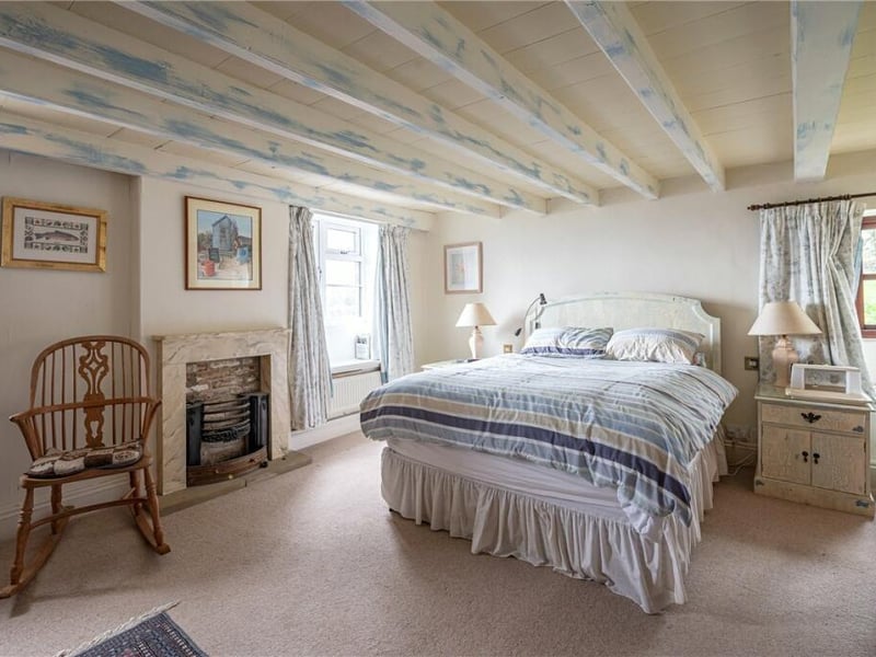 A light and spacious bedroom with a feature fireplace.