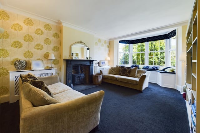 Another reception room with fireplace, stove and plenty of natural light, thanks tot he bay window with window seat.